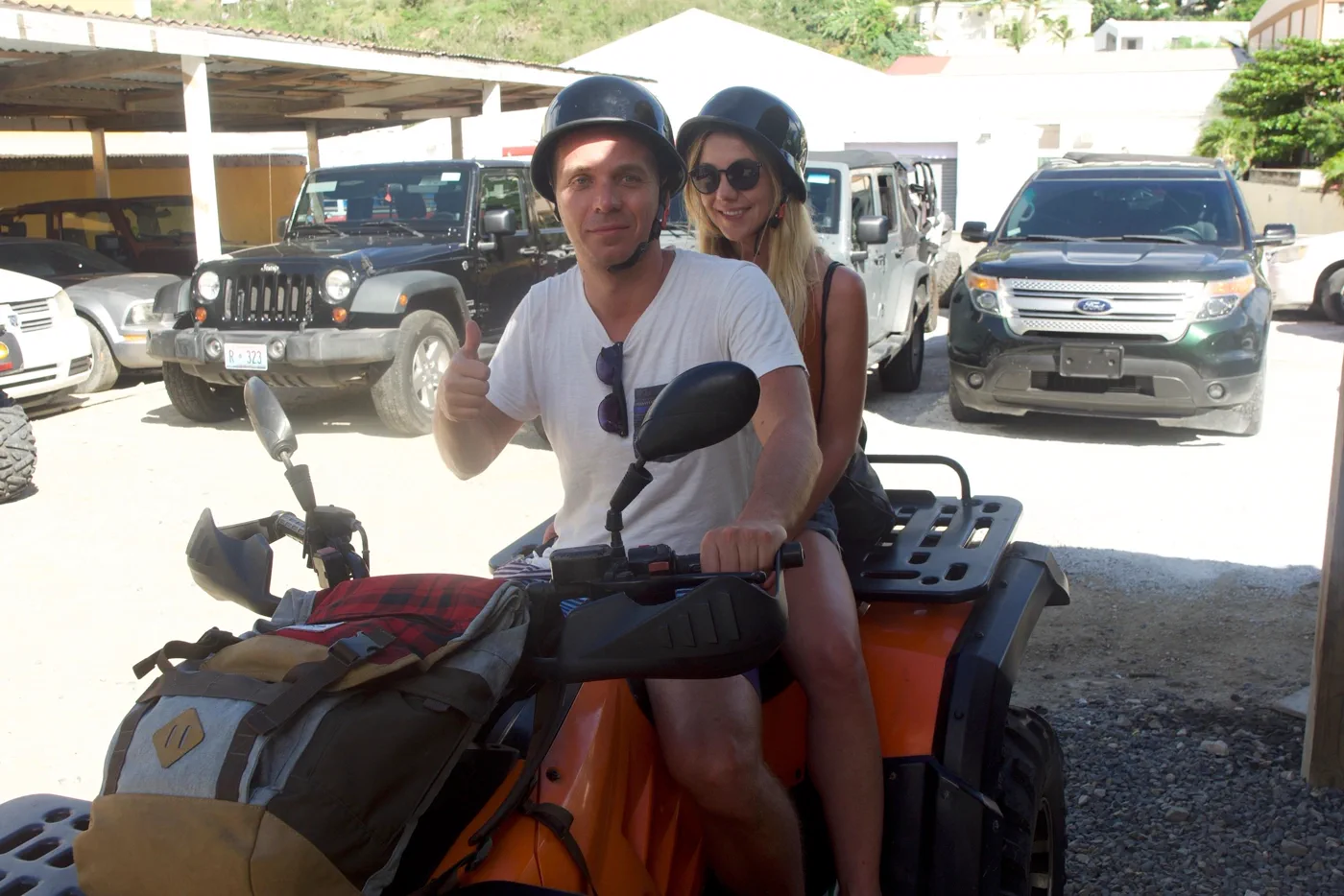 Couple wearing helmets on an ATV Island quad