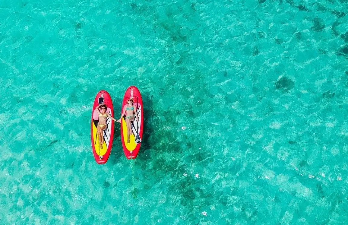 Caribbean Paddling stand up paddleboard on clear water near Pinel Island