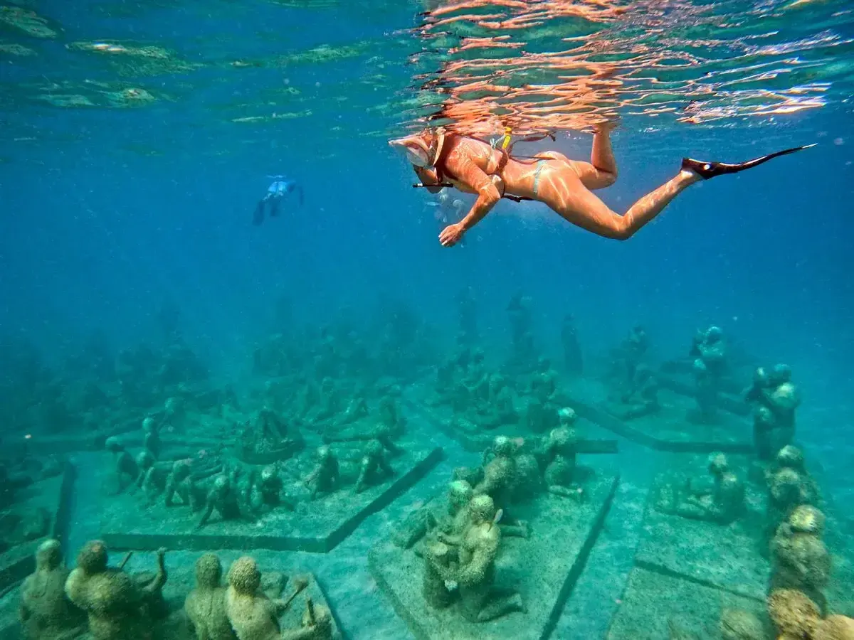 Snorkeler above submerged sculptures at Under SXM in Little Bay