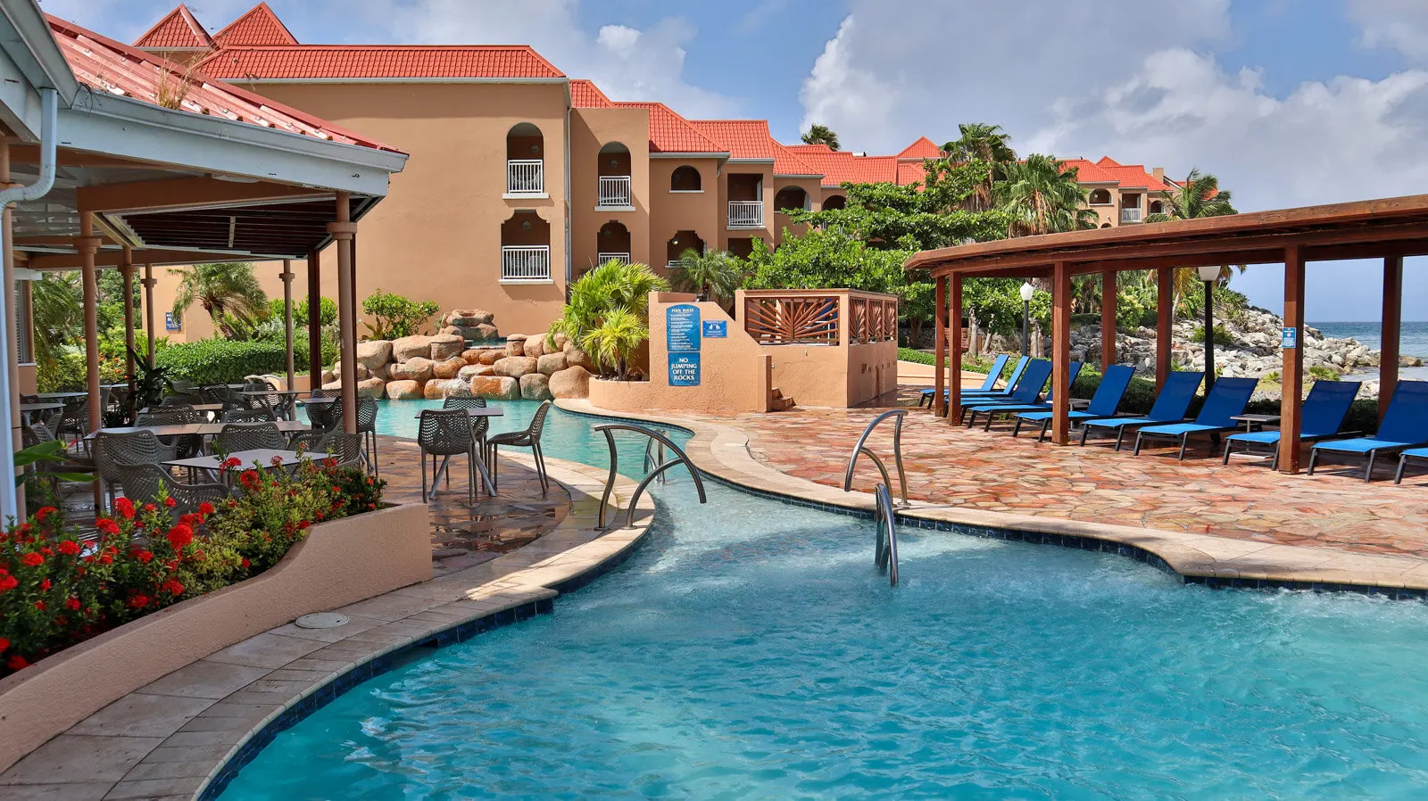 Pool deck and red-roof buildings at Divi Little Bay