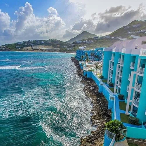 Turquoise resort buildings perched on the rocks