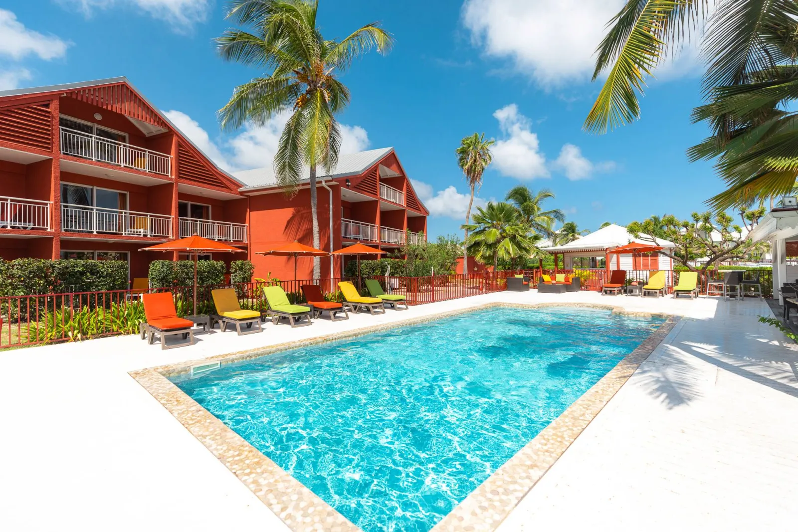 Pool and red-roof buildings at Palm Court Residence