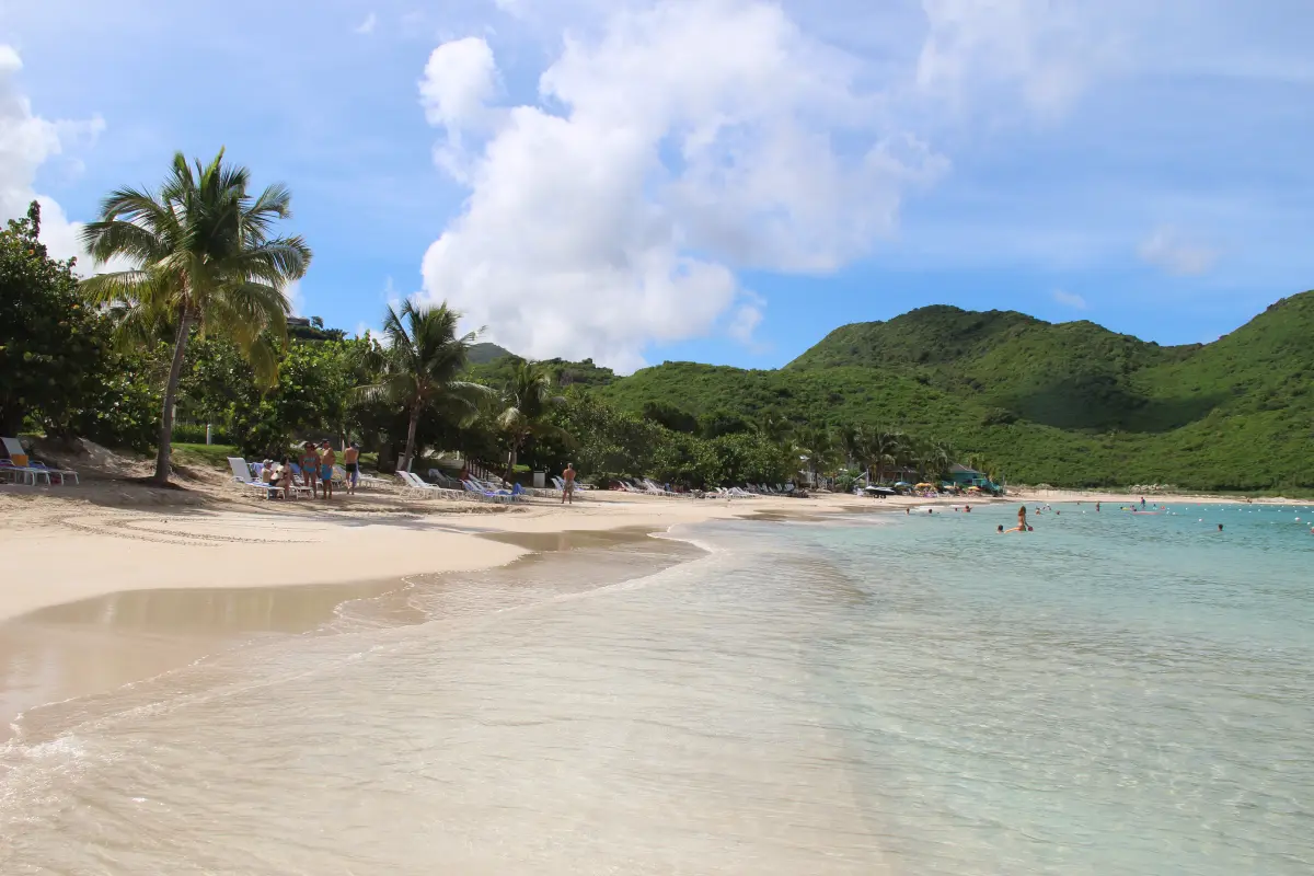 Pale sand and green hills around Anse Marcel Beach