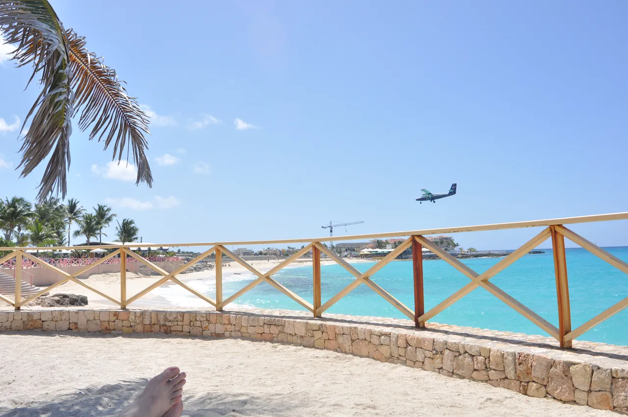 Small plane on approach to Princess Juliana Airport with neighbouring beach and turquoise water