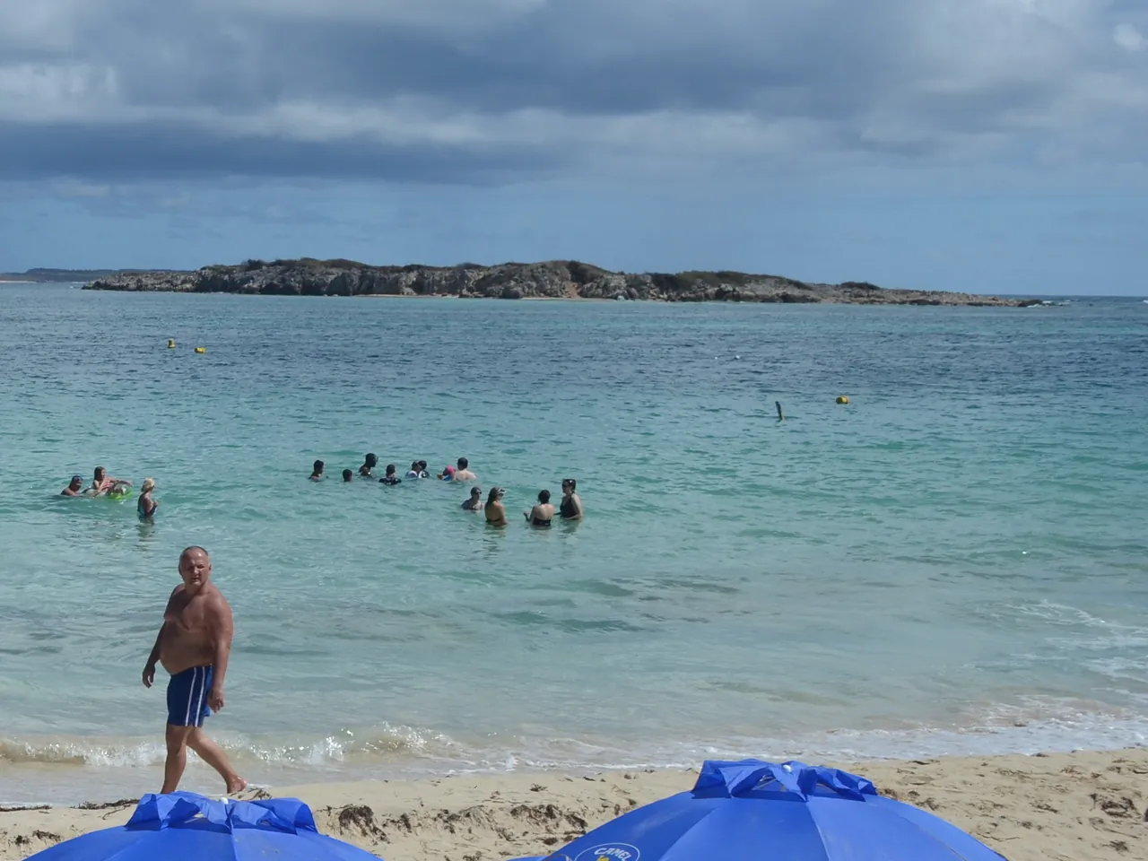 Swimmers and snorkelers facing Green Cay from Orient Bay in Saint Martin