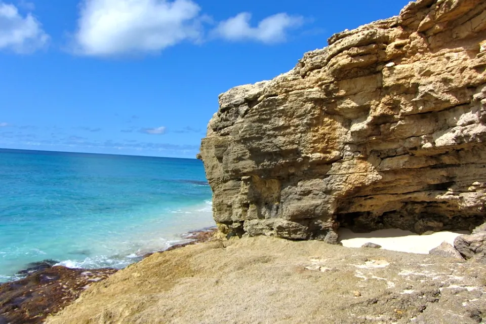 Carved cliffs of Cupecoy Beach beside turquoise water
