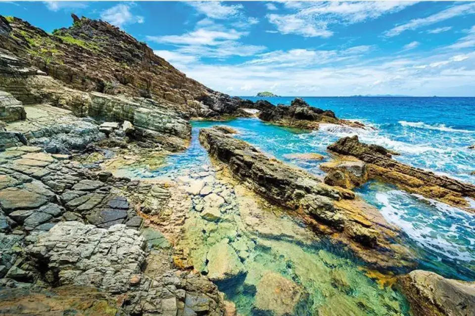 Rocks and natural pool at Geneve Bay in calm seas