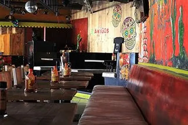 Red banquettes and Day of the Dead decor at the 3 Amigos sports bar in Maho