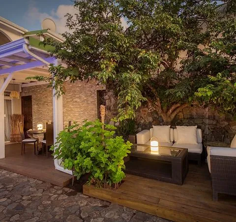 Entrance and wooden terrace of 978 Sanctorum with tropical tree and lounge banquettes