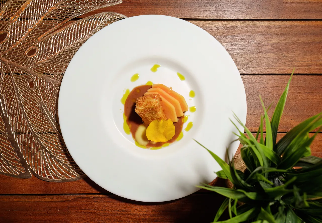 Overhead view of a gastronomic plate at 978 Sanctorum on a wooden table