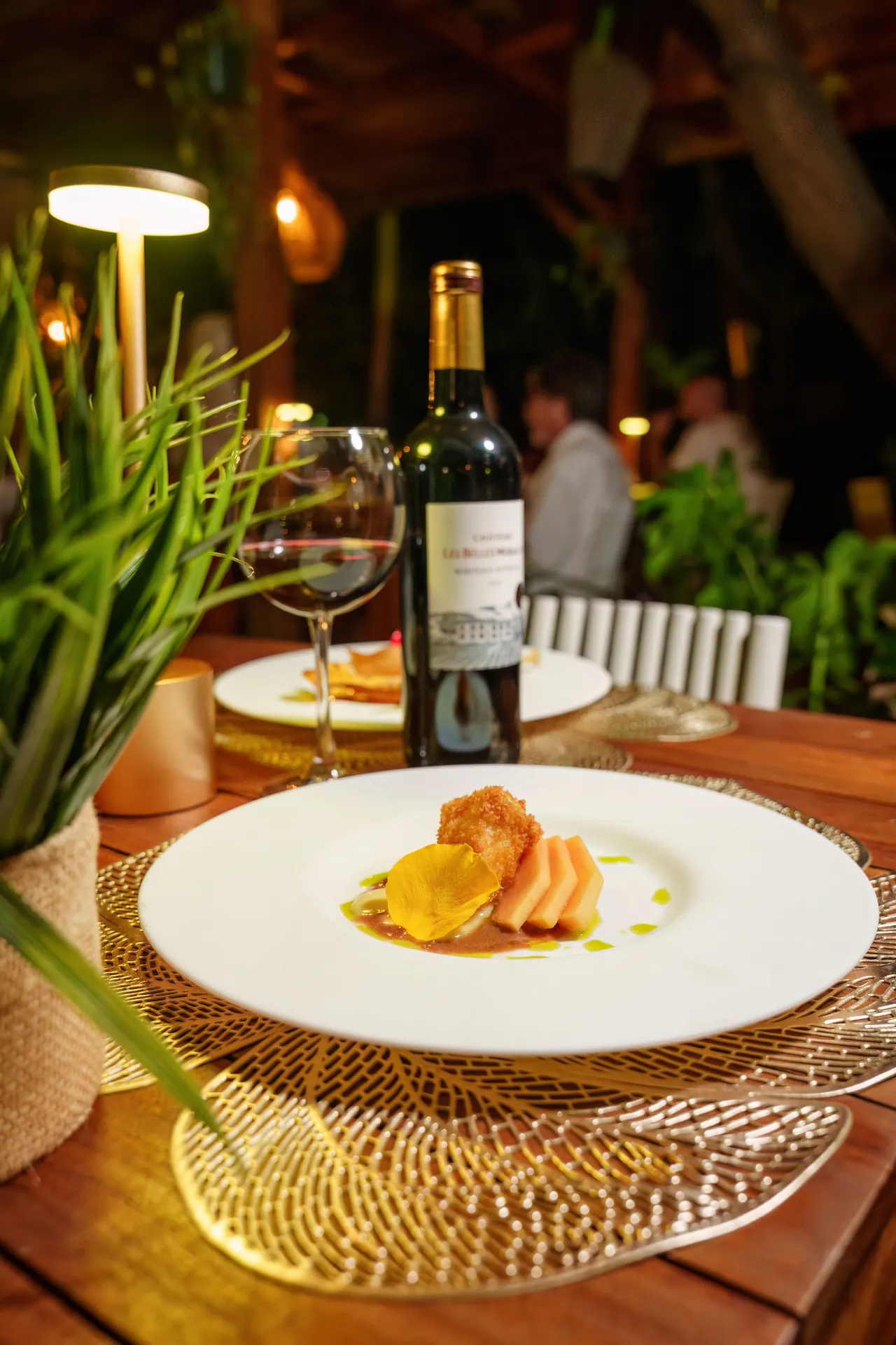 Gastronomic Creole dish at 978 Sanctorum served with a bottle of red wine
