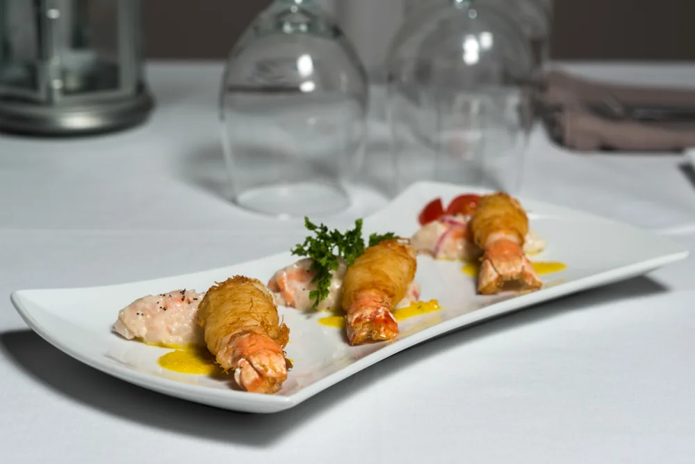 Kataifi-wrapped shrimp served on white linen at L'Astrolabe