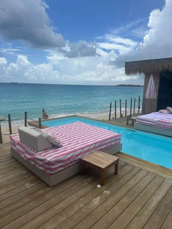 Four-poster daybed and oceanfront pool at Babacool, boho beach-club vibe