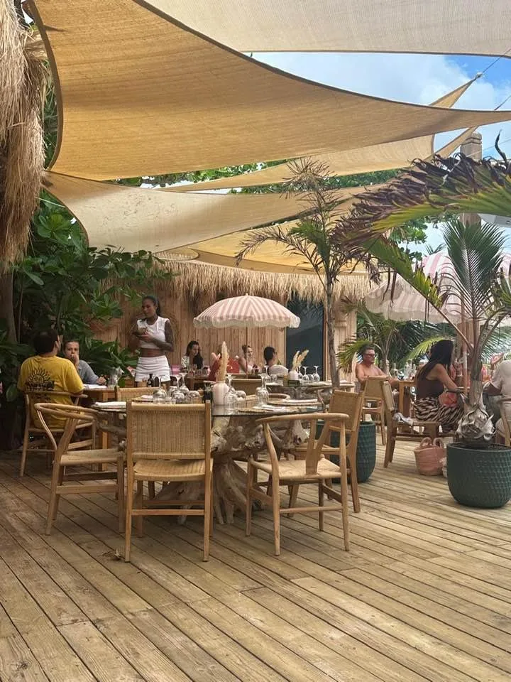Babacool dining tables under shade sails and palms, lunch with feet in the sand