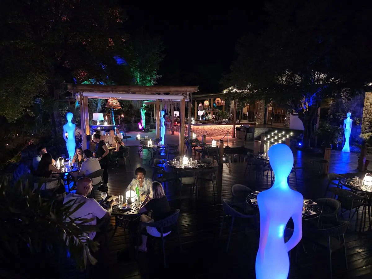 Bamboo House SXM in Cole Bay - night terrace with blue-lit statues and set tables