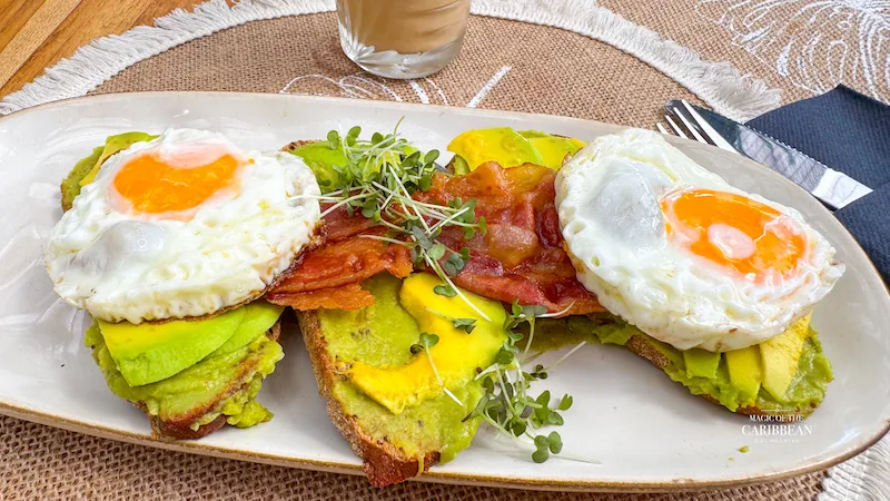 Avocado toast with fried eggs and bacon served at Baratié SXM brunch