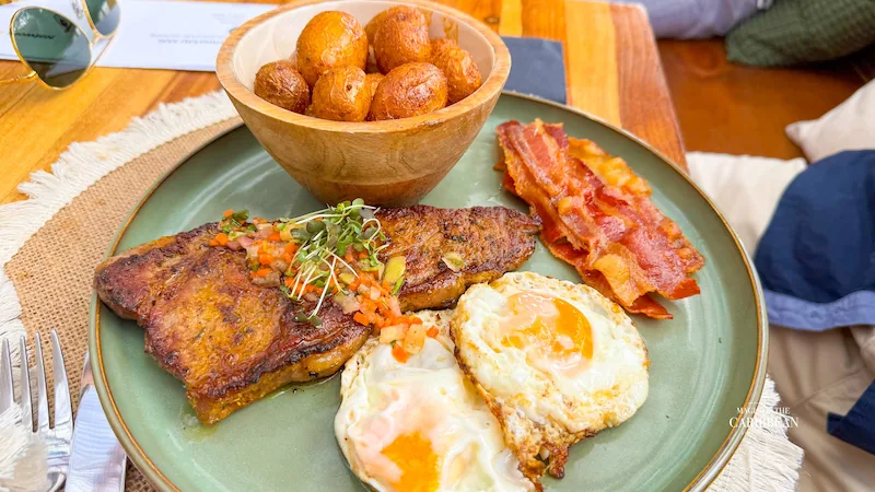 Baratié SXM breakfast plate with eggs, bacon, fried plantain and accras