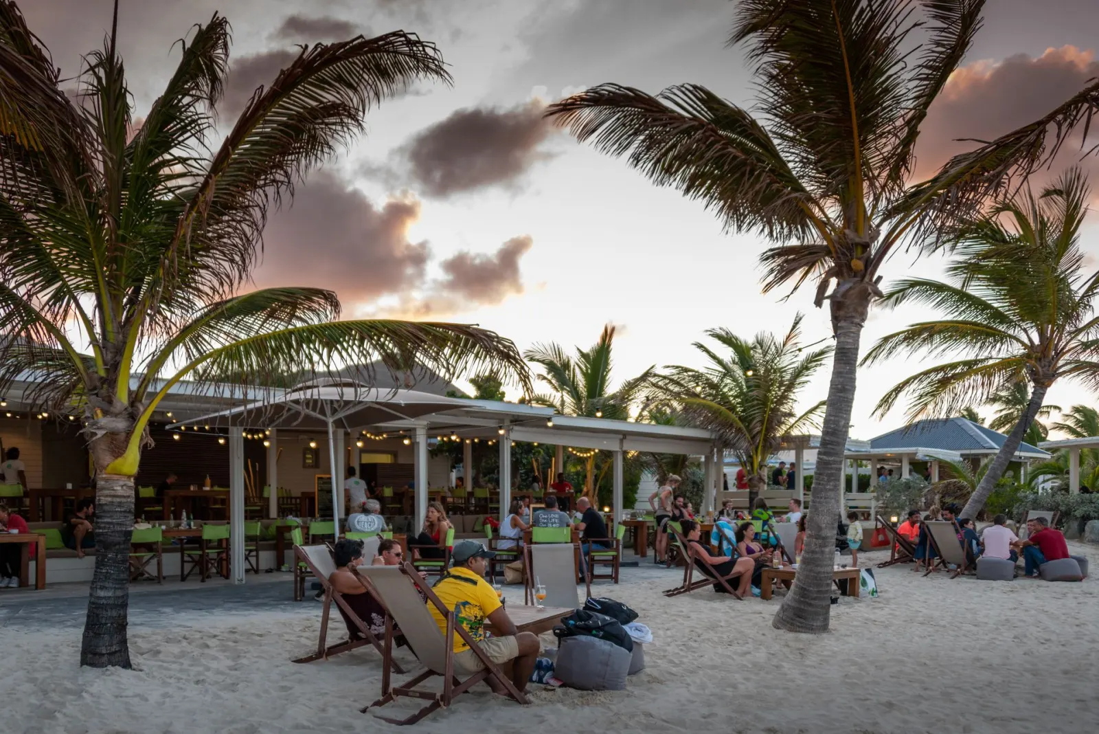 Bikini Beach at Orient Bay - beach terrace with palm trees and sunset over Orient Bay