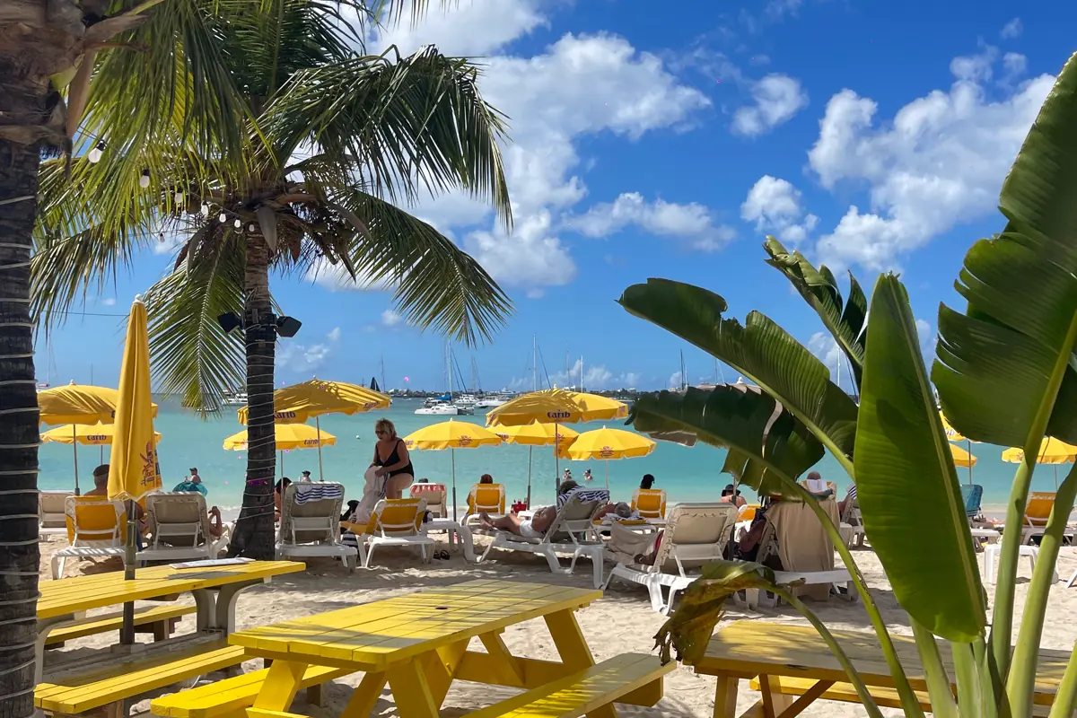Yellow tables and umbrellas at Buccaneer Beach Bar facing Kim Sha Beach