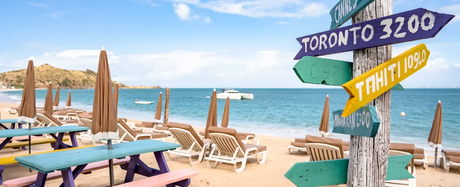 Captain Frenchy - colorful picnic tables and Tahiti Toronto signpost on Grand Case Beach