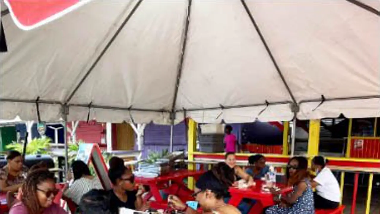 Captain’s Rib Shack - Red outdoor tables in the shaded seating area