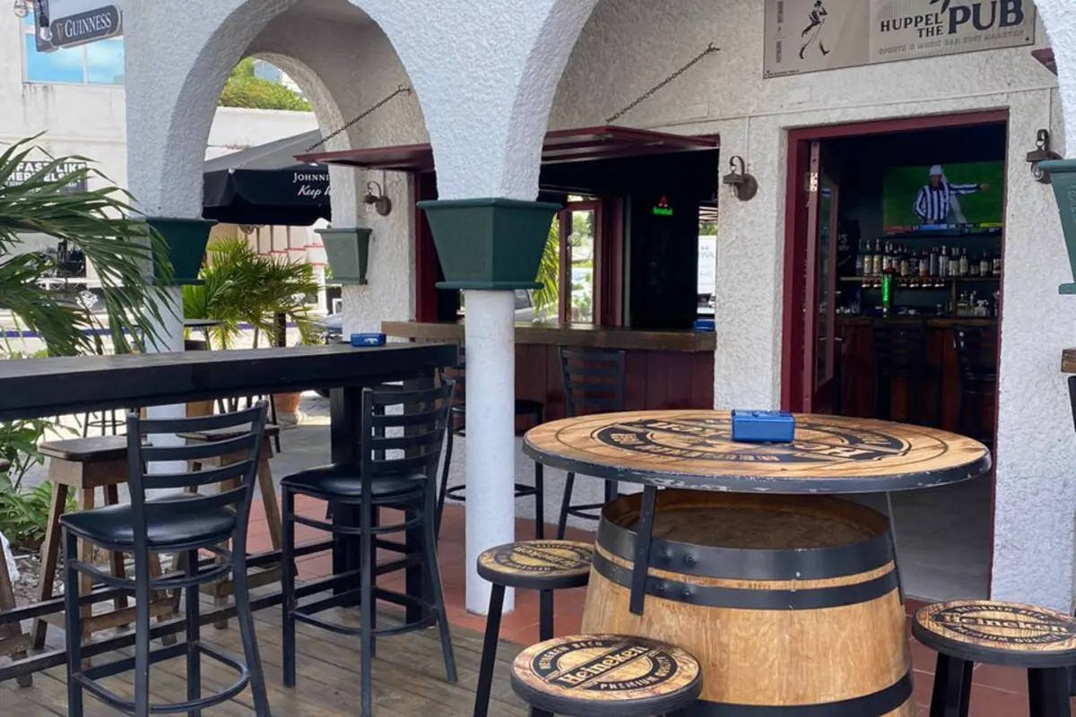 Open-air terrace at Huppel The Pub with high tables and pub entrance
