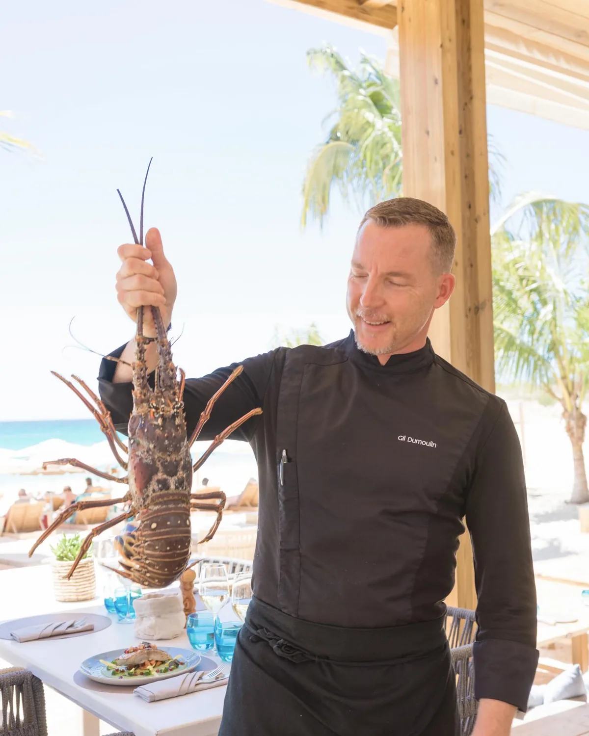 Chef Gil Dumoulin presenting a fresh spiny lobster inside Kalatua