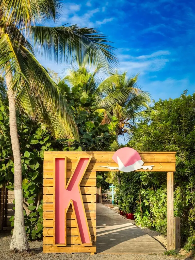 Karakter in Simpson Bay - beach club entrance with pink K letter and palm trees