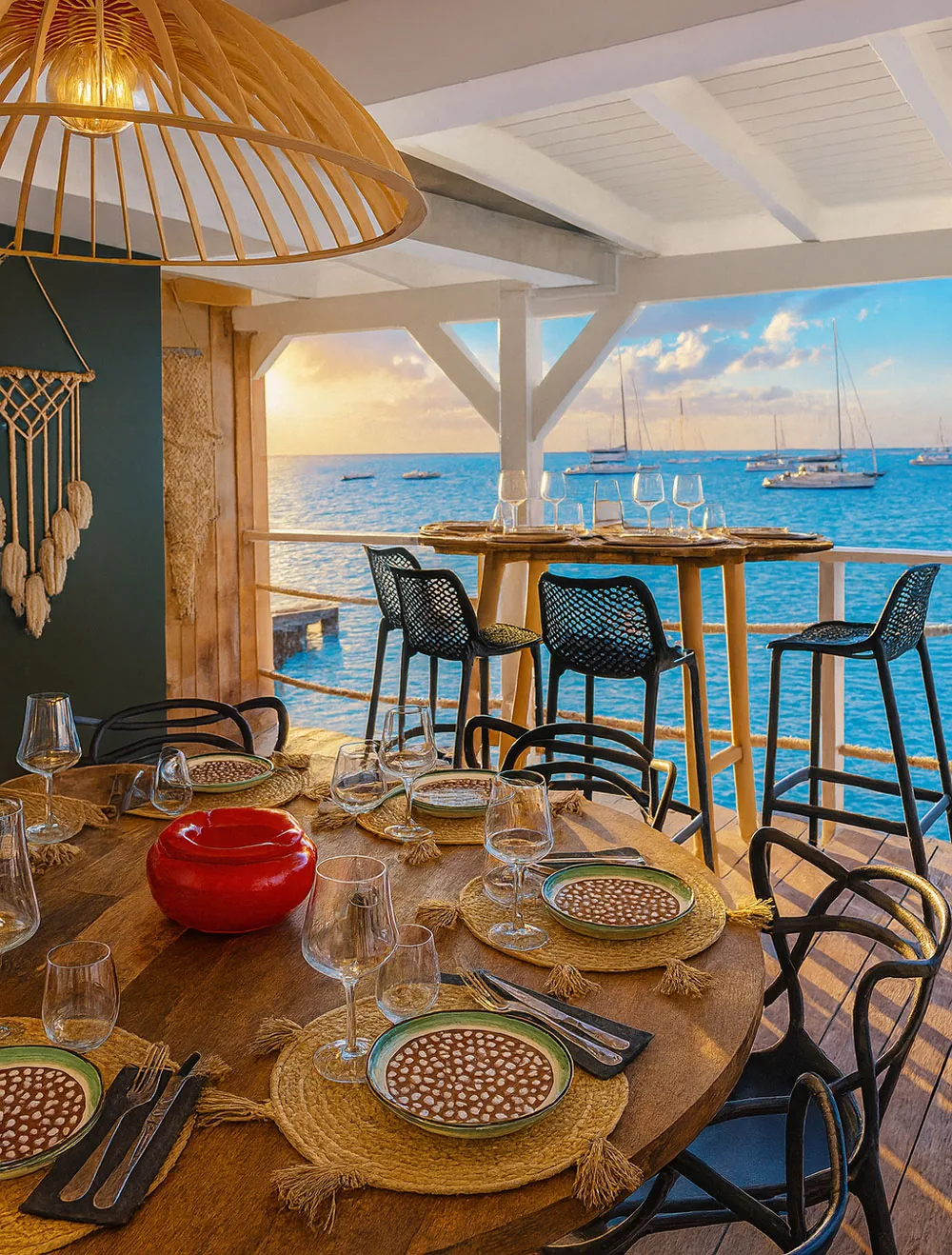 Wooden terrace at Korner SXM in Grand Case with a set table and yachts at sunset in the background