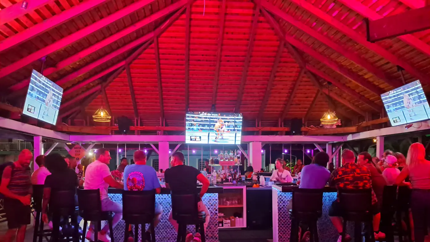 Kraken Raw Bar SXM - central bar with sports screens and pink neon atmosphere