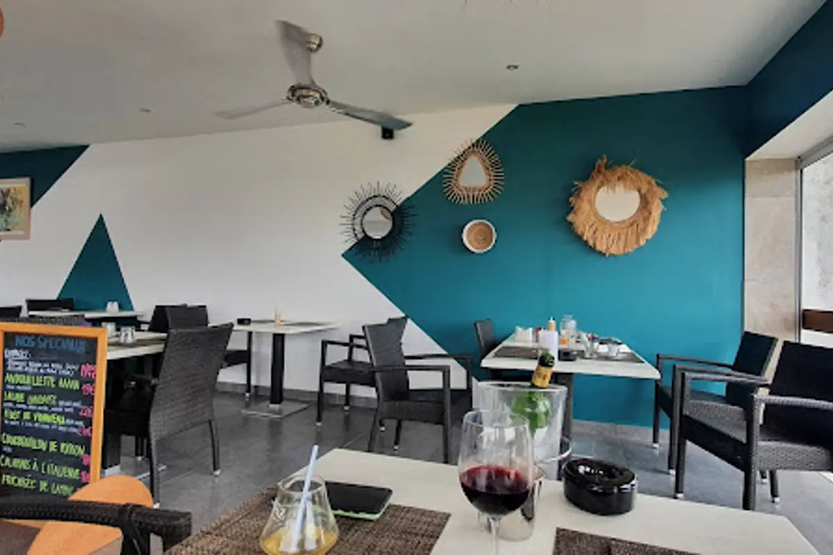 Open dining room at Le Grand St Martin with blue decor and tables in Marigot