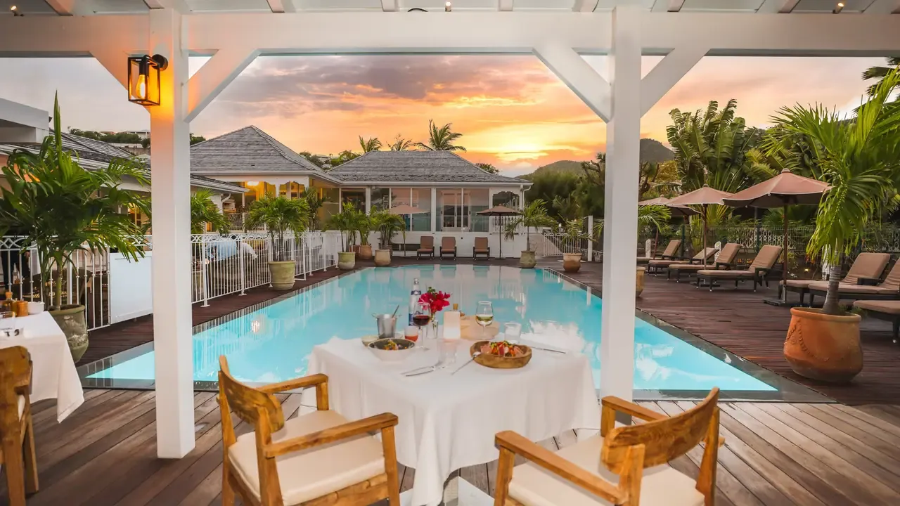 Set table by the pool at Le Sud restaurant at sunset