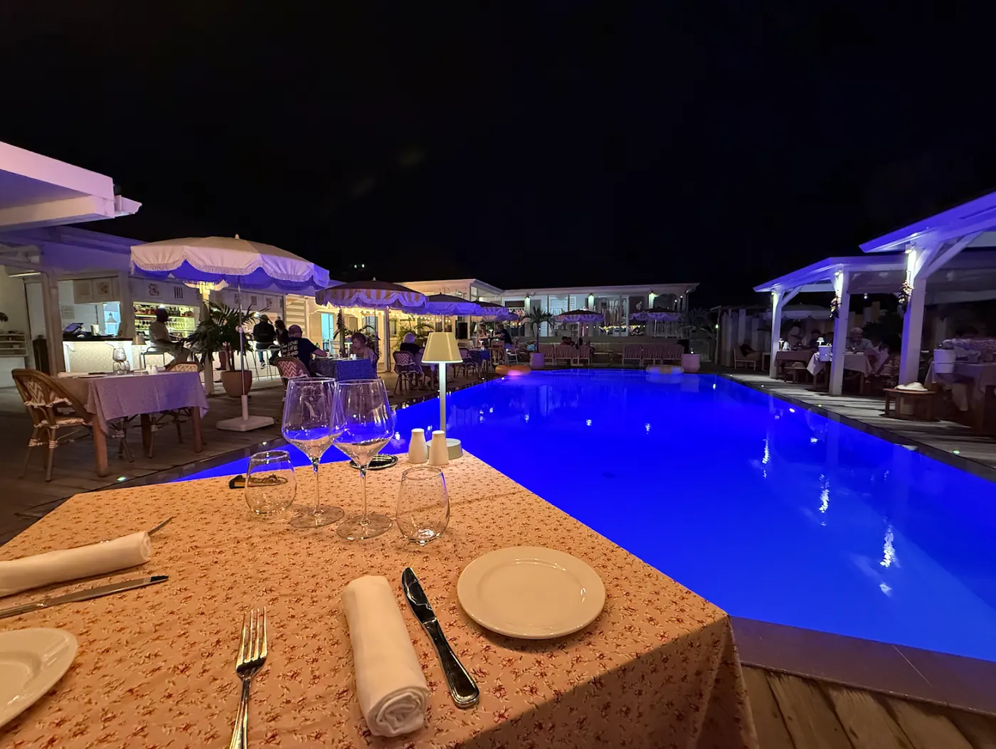 Night dinner by the illuminated pool at Le Sud restaurant