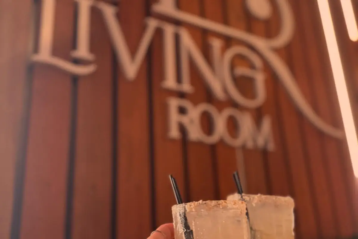 Living Room SXM cocktails in front of the restaurant wall logo