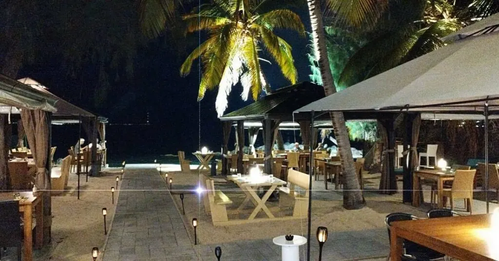 Mezza Luna terrace at night with lit tables by the beach