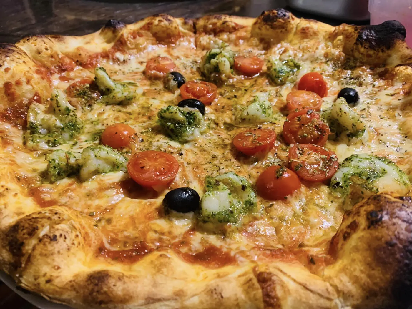 Italian pizza at Mezza Luna with cherry tomatoes, basil and melted cheese