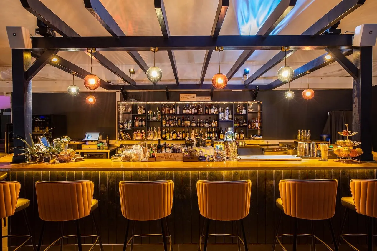 Mimosa Skylounge bar with mustard velvet stools and glass globe pendants