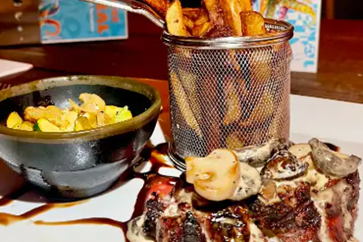 Grilled dish with fries and Caribbean sides at Nowhere Special