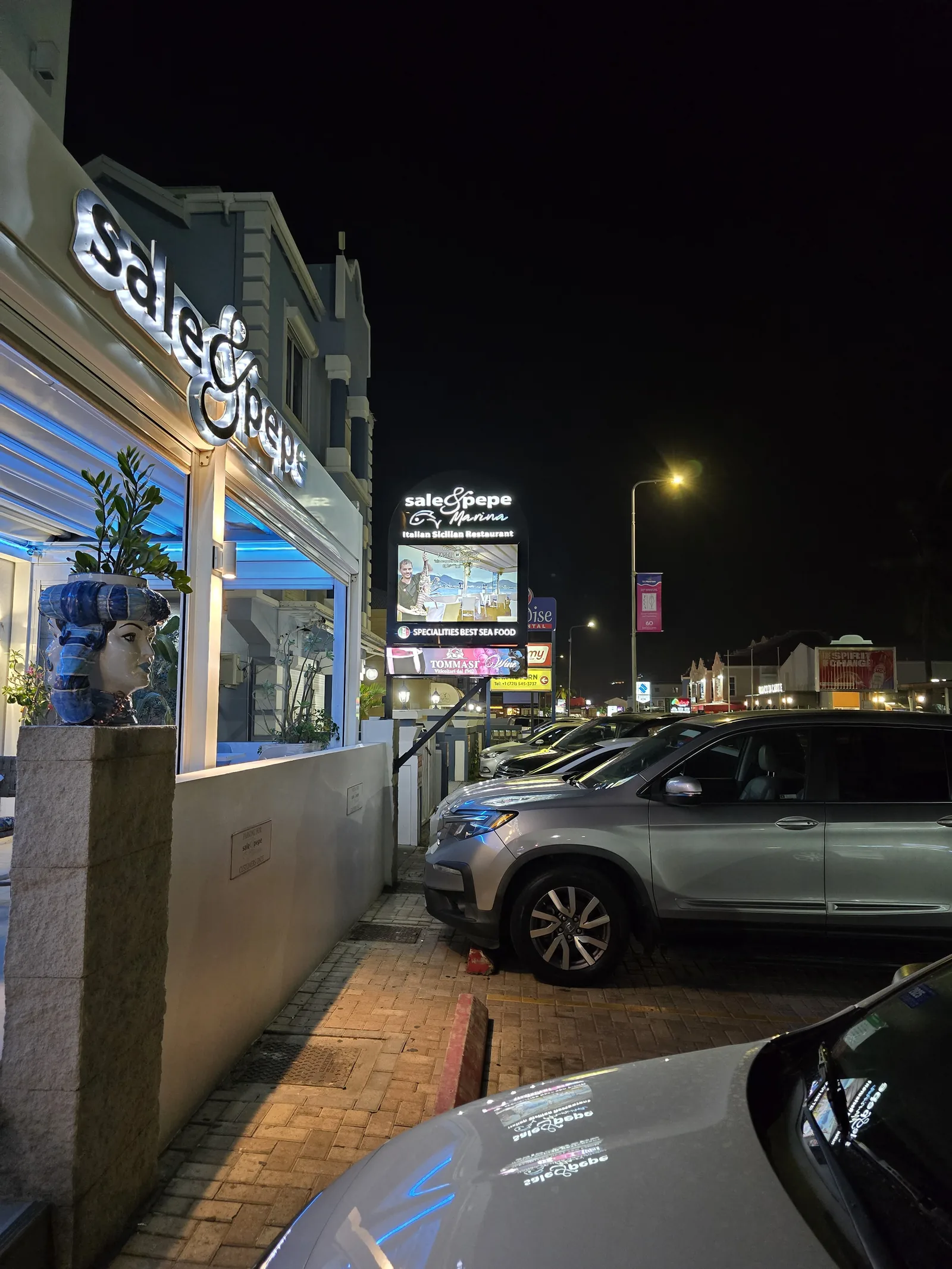 Lit-up facade of the Sale & Pepe Marina restaurant in Simpson Bay with its neon sign