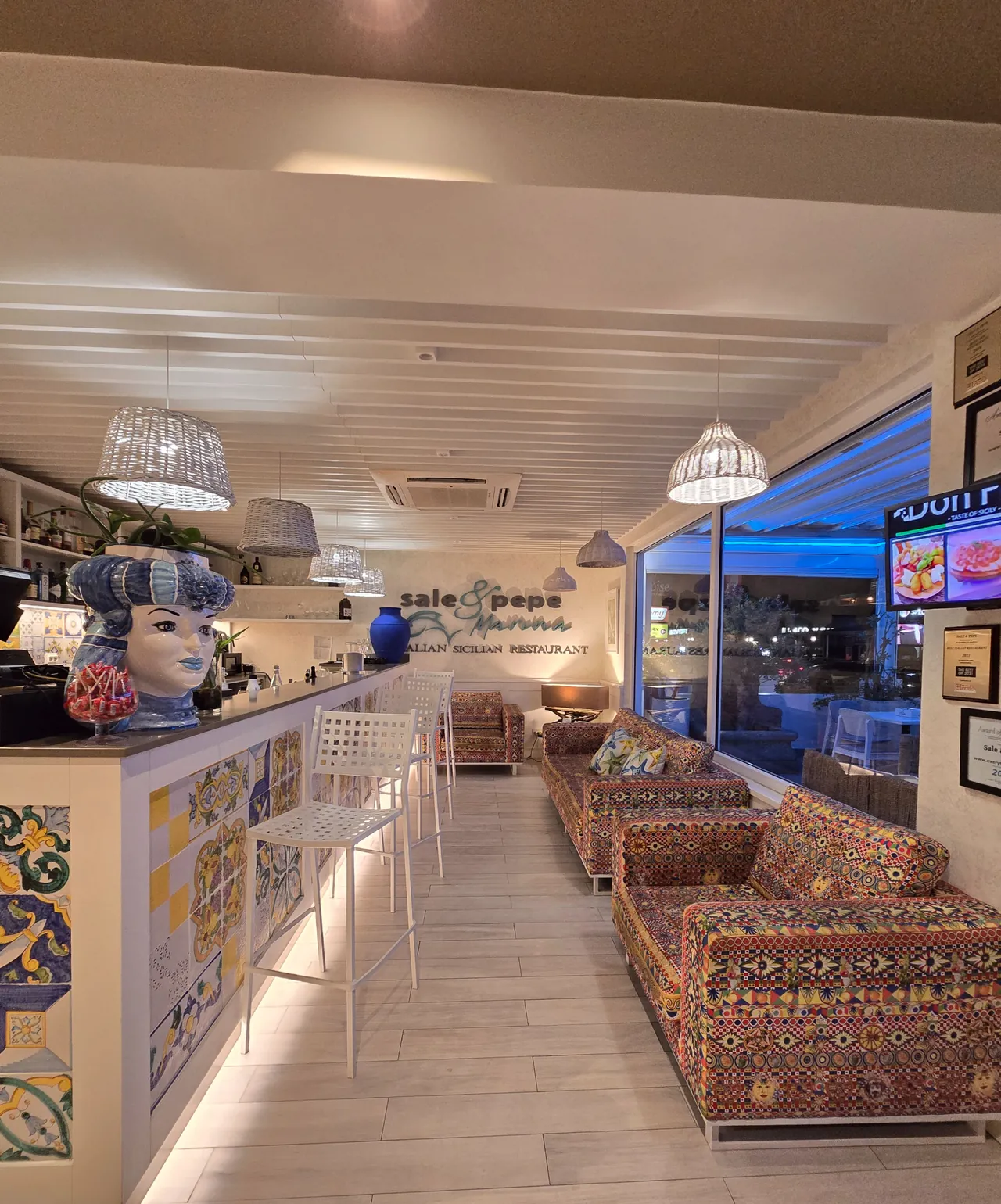 Indoor bar at Sale & Pepe with Testa di Moro head, Sicilian tiles and colorful banquettes