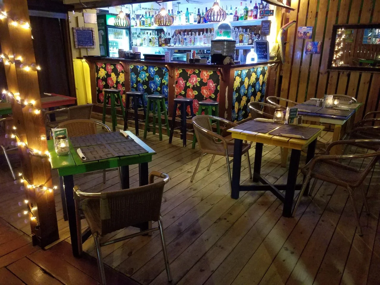 Colorful bar at The Palms in Pelican Key with hand-painted floral barstools and fairy lights