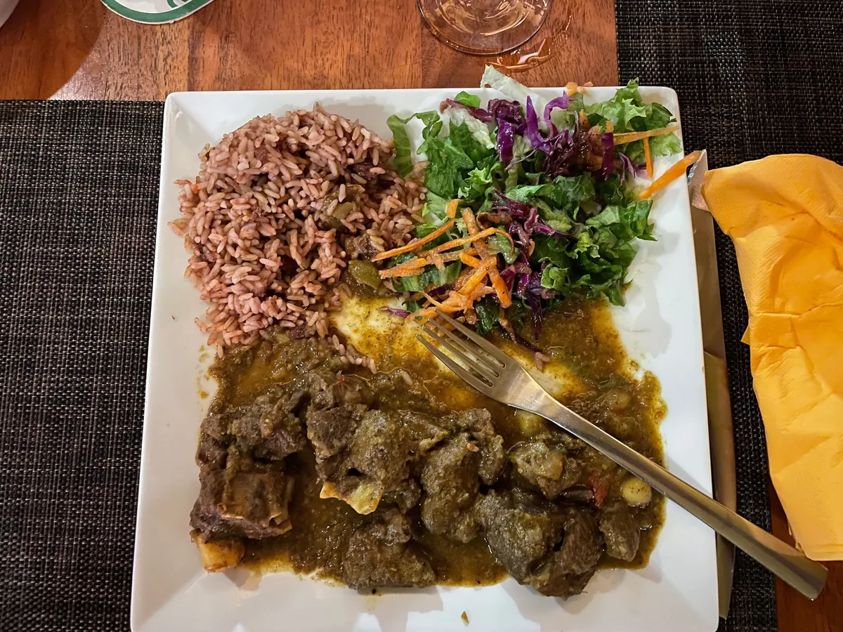 Trinidad-style goat curry served with red bean rice and salad at The Palms