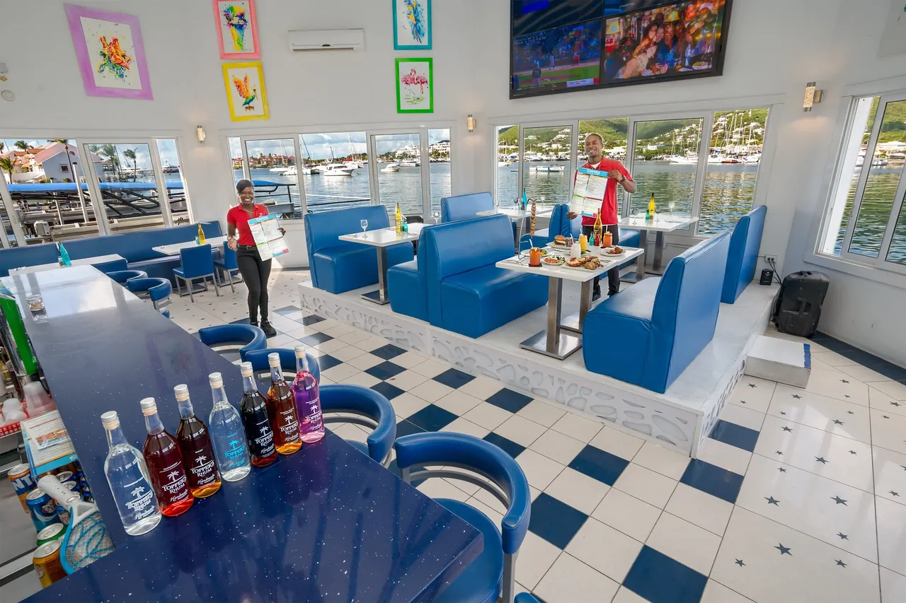 View of Topper's dining room with set tables facing the moored yachts