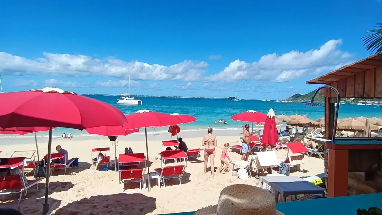 Tropic's Beach Bar SXM - Red umbrellas and sun loungers on Grand Case beach