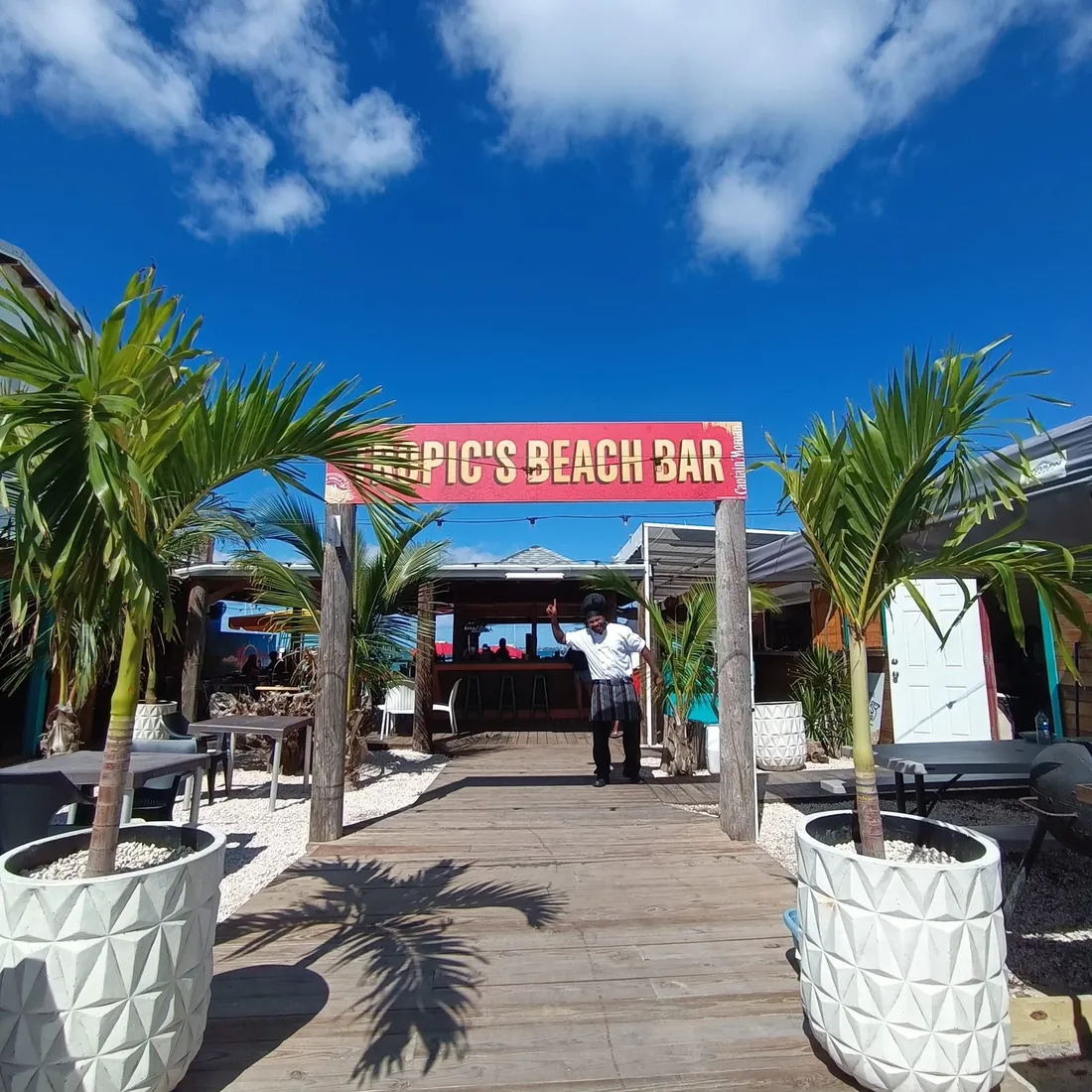 Tropic's Beach Bar SXM - Entrance with sign and palm trees on Grand Case boulevard