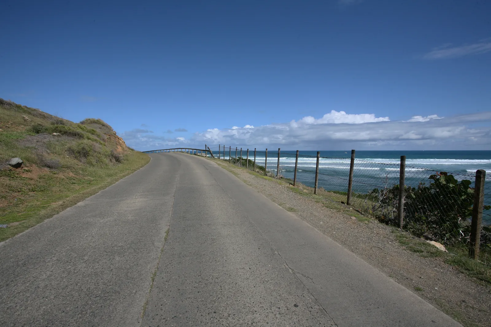 Wild Atlantic coast of Saint Martin / Sint Maarten with waves, coastal road and open horizon