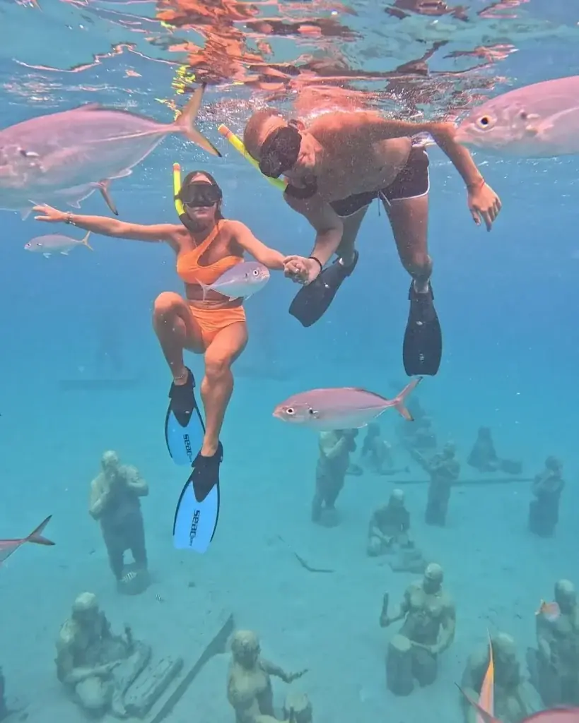 Couple snorkeling above Taino sculptures at the Under SXM park