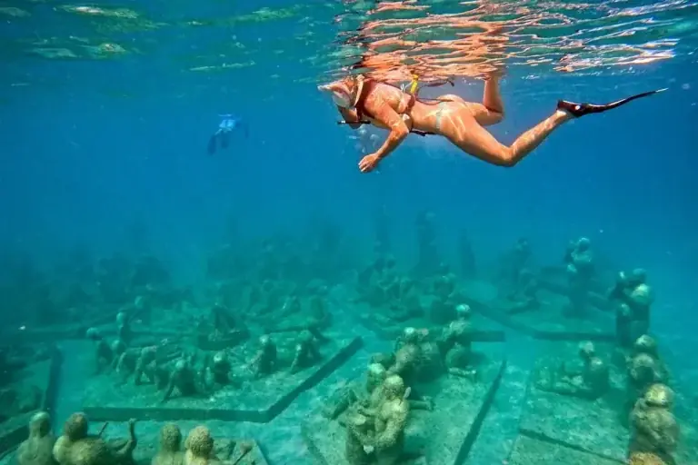Snorkeler above submerged sculptures at Under SXM in Little Bay