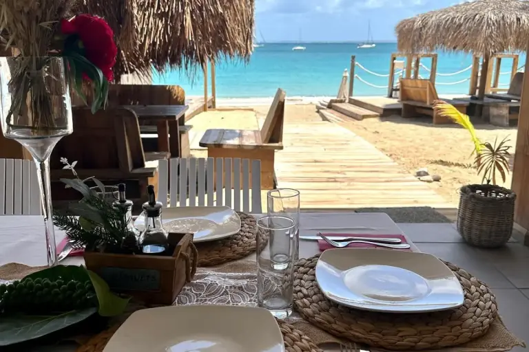 978 Beach Lounge - Terrace table looking out over the beach and straw huts