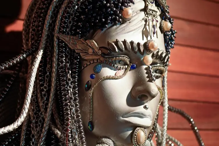Mannequin face adorned with Carnival beads and jewels
